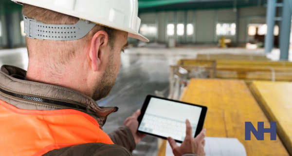 IT Skill and Construction Site Experience Man in hard hat using iPad on a construction site